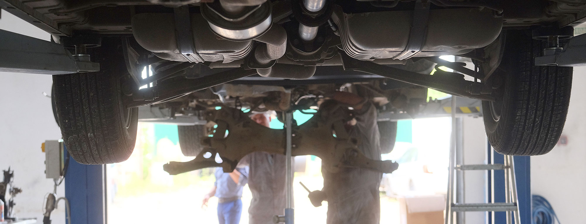 Mechanics Working on Hoisted Vehicle